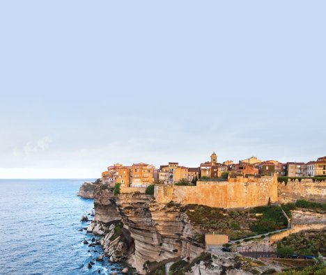 Seabourn luxury small ship anchored in an azure Mediterranean cove with water sports marina