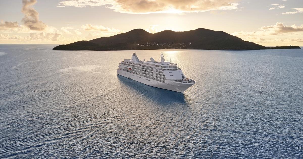 Silversea ultra-luxury cruise ship sailing gracefully near historic Mediterranean coastline