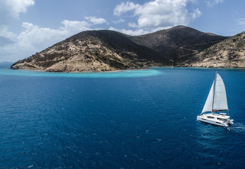 The Moorings luxury sailing catamaran anchored in a crystal-clear turquoise cove in the British Virgin Islands